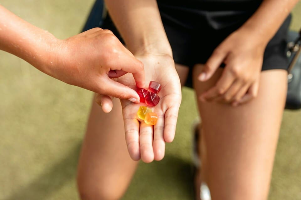 Person sharing gummies in hand